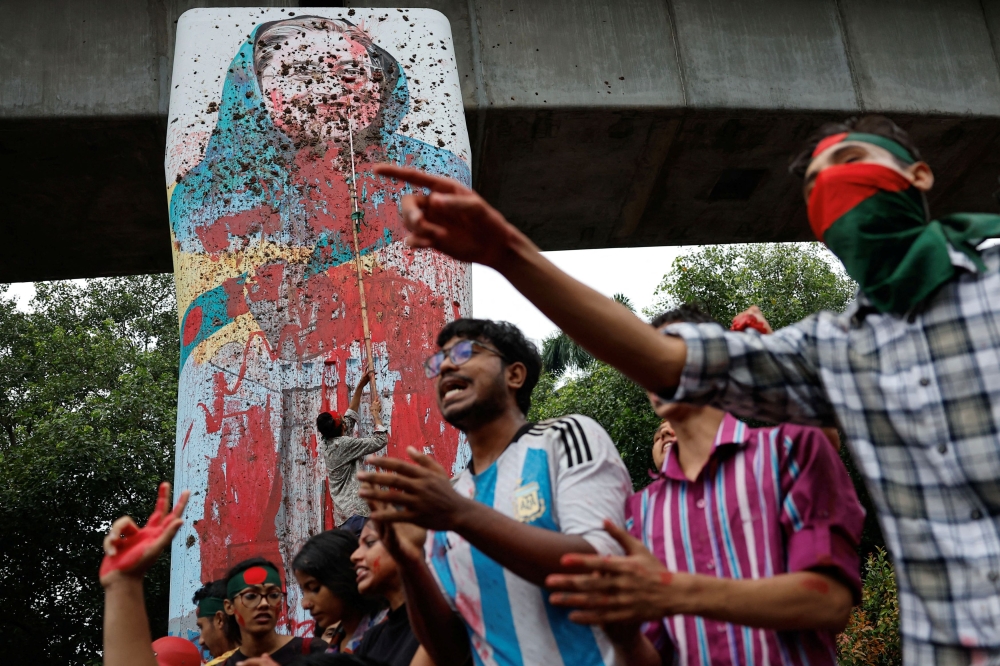 Protesters shout slogans as they vandalise a mural of Bangladeshi Prime Minister Sheikh Hasina with paint and mud, demanding her resignation at Teacher Student Center (TSC) area of University of Dhaka in Dhaka August 3, 2024. — Reuters pic  