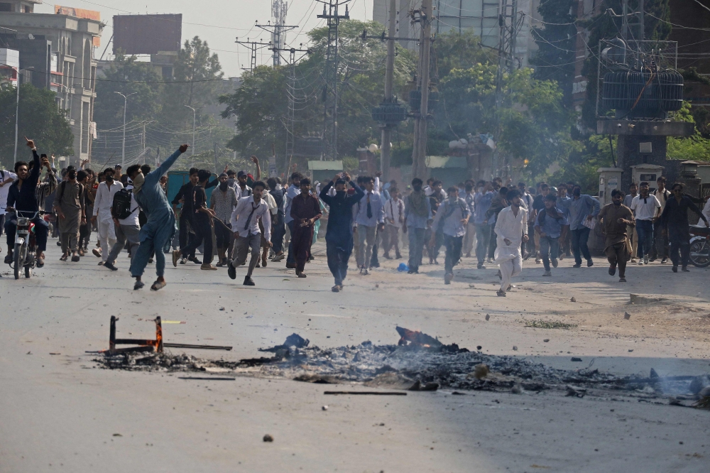 Students hurl stones towards security personnel during a demonstration to condemn the alleged rape of a female student in Rawalpindi on October 17, 2024. — AFP pic