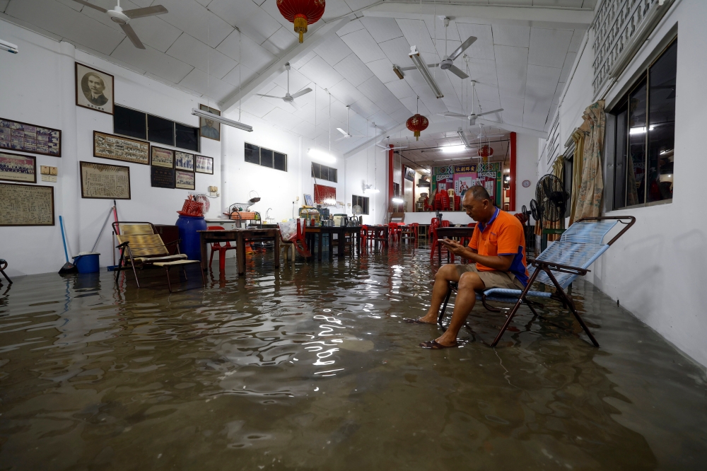 A resident of Kampung Nelayan Bagan Hailam is seen amid flood waters in his home, following the high tide phenomenon this morning in Port Klang, on Oct 18, 2024. — Bernama pic