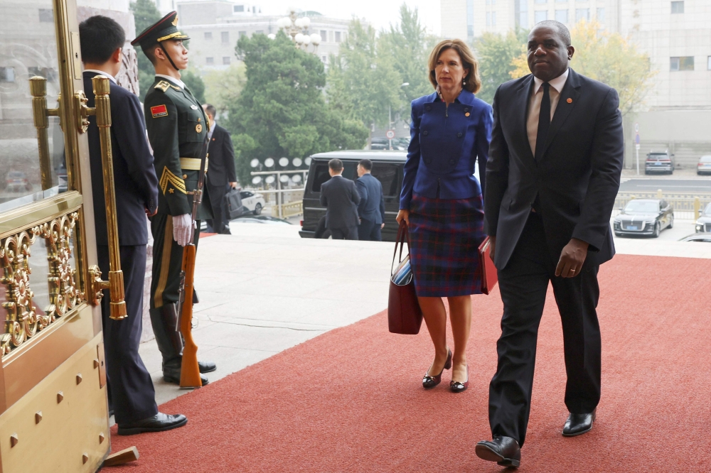 Britain’s Foreign Secretary David Lammy (right) and British Ambassador to China Caroline Wilson arrive at the Great Hall of the People in Beijing, China on October 18, 2024. — AFP pic