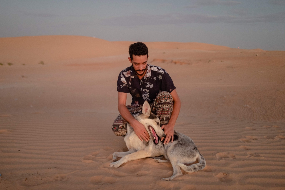 Ahmed Maham poses with Koyo, a Siberian husky dog traditionally bred for the Arctic cold, on the Saharan dunes out of Nouakchott, Mauritania on October 9, 2024. — AFP pic