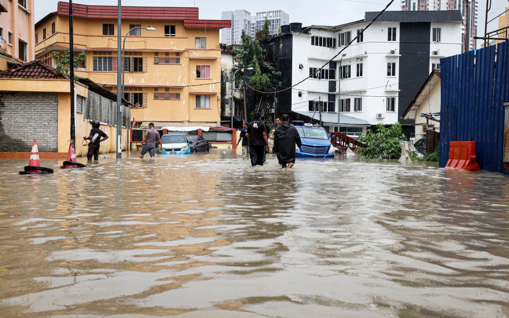 People wade through floodwaters in Kuala Lumpur October 15, 2024. — Bernama pic