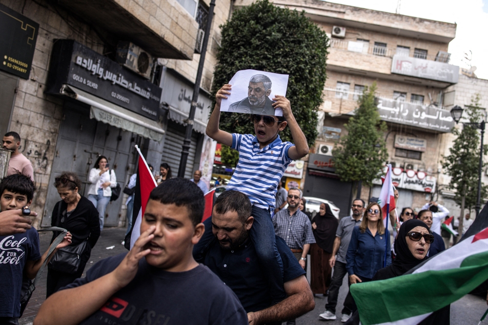 A young Palestinian boy holds up a portrait of slain Hamas leader Yahya Sinwar during a rally in Ramallah, in the Occupied-West Bank on October 18, 2024. — AFP pic