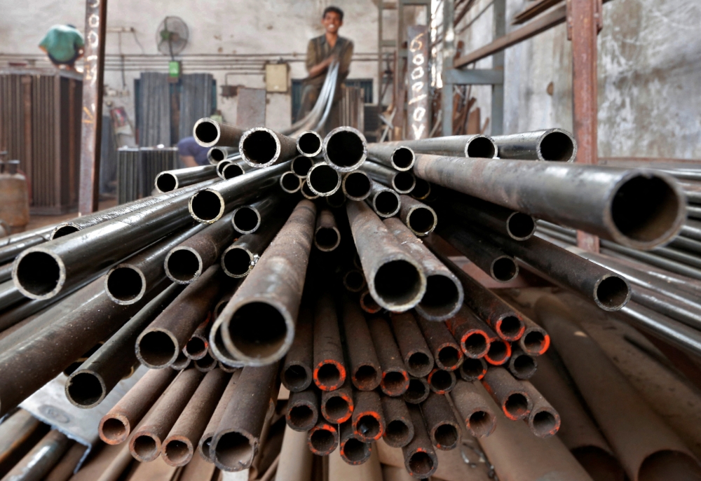 A worker stacks steel pipes in Ahmedabad in this file photo taken on November 4, 2014. The proposed introduction of the carbon tax in 2026 on the steel, iron and energy industries addresses environmental concerns, collectively creating a more robust and equitable tax system and supporting long-term economic and environmental goals. — Reuters pic  