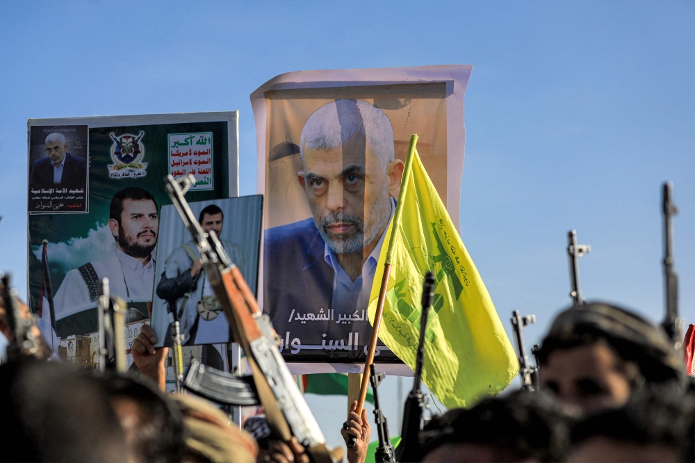 A supporter of Yemen’s Houthis holds up a picture of slain Hamas leader Yahya Sinwar  during a rally in Sanaa on October 18, 2024. — AFP pic