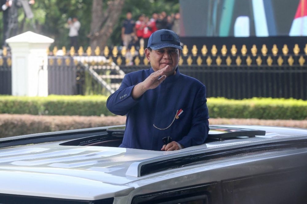 Indonesia's newly sworn-in President Prabowo Subianto waves as he arrives at the Presidential Palace during the presidential inauguration ceremony in Jakarta on October 20, 2024. — AFP pic