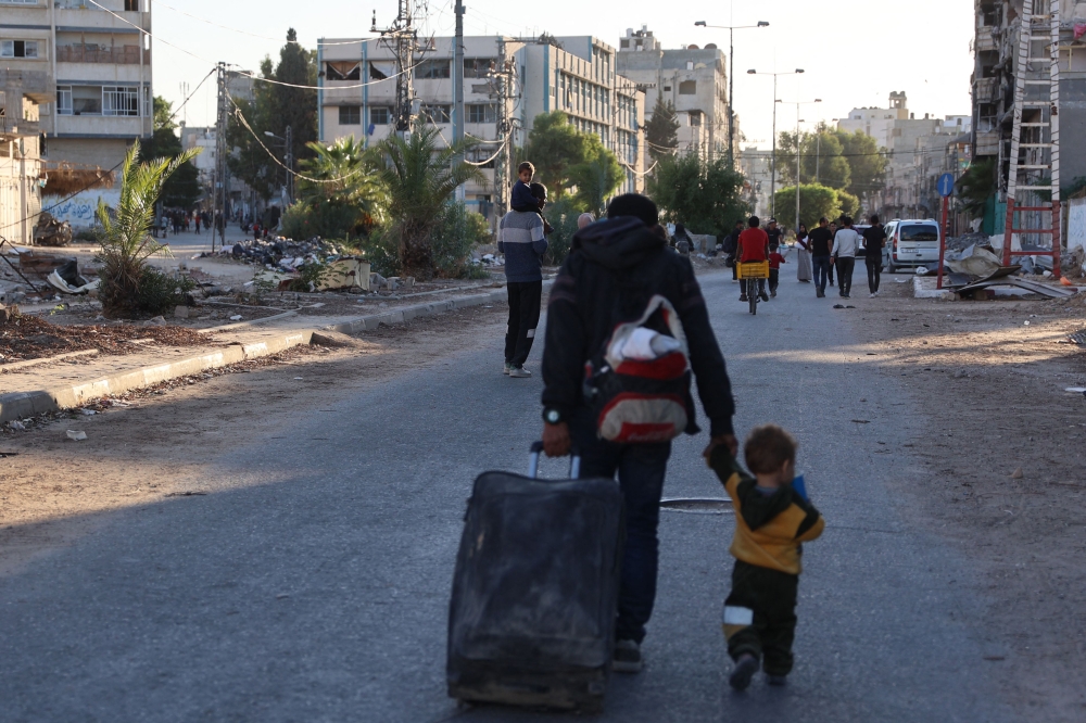 Displaced Palestinians, ordered by the Israeli army to leave the school in Beit Lahia where they were sheltered, arrive in Gaza City on October 19, 2024. — AFP pic