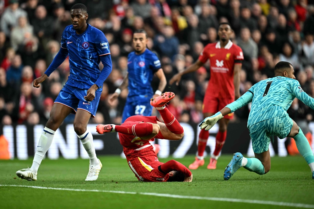 Liverpool's Curtis Jones falls after running into Chelsea's goalkeeper Robert Sanchez during the English Premier League football match between Liverpool and Chelsea at Anfield in Liverpool, north west England on October 20, 2024. — AFP pic