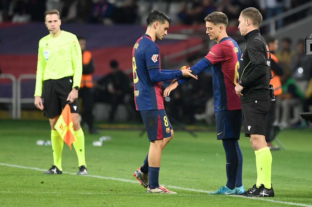 Barcelona's midfielder Pablo Gavi receives the captain's armband from fellow midfielder Pedri during the Spanish league football match between FC Barcelona and Sevilla FC at the Estadi Olimpic Lluis Companys in Barcelona on October 20, 2024.— AFP pic