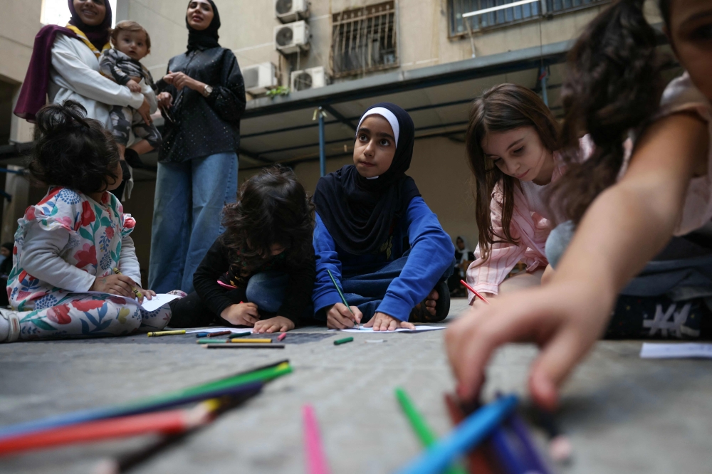Children who fled Israeli bombardment in southern Lebanon, attend a drawing workshop organised by volunteers, at a shelter in Beirut where they took refuge with their families, on October 20, 2024, amid the ongoing war between Israel and Hezbollah. — AFP pic