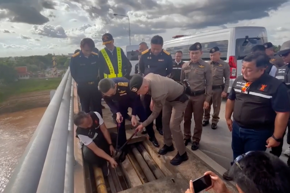 Screengrab of National Broadcasting and Telecommunications Commission video showing officials cutting off the internet cable across the bridge.