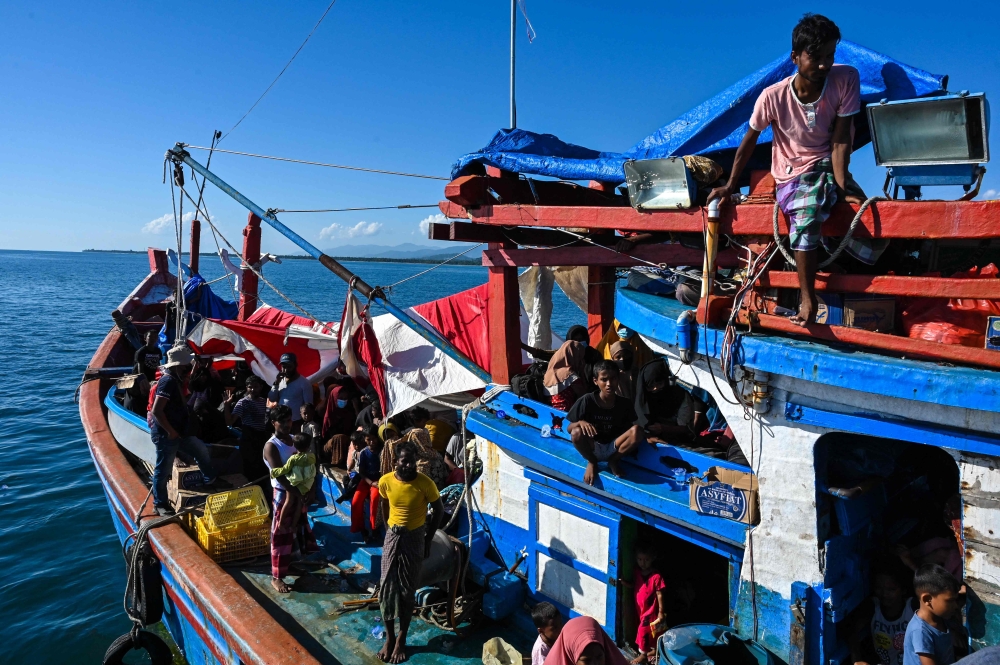 Rohingya refugees on a boat wait to be pulled by a relief vessel to anchor closer to shore off the coast of Labuhan Haji in Southern Aceh province on October 21, 2024. — AFP pic