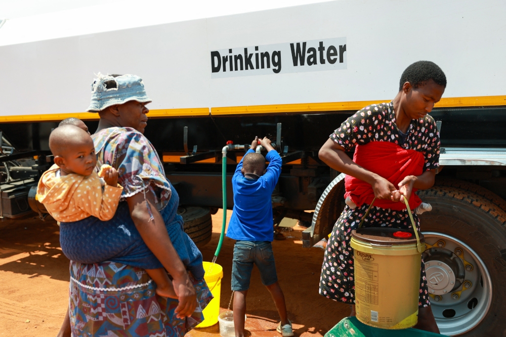 Residents of Liliba carry their buckets filled with water from a water tanker provided by the City of Ekurhuleni in Tembisa in South Africa on October 15, 2024. — AFP pic 