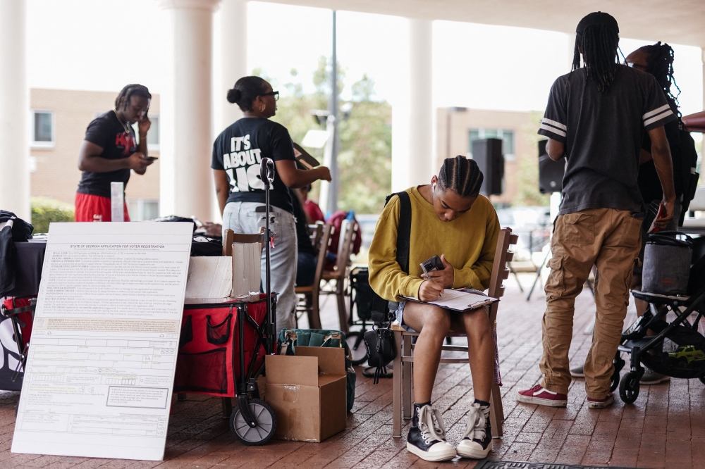 A Morehouse student fills out a voter registration form at a voter registration booth at Morehouse College on August 19, 2024, in Atlanta, Georgia. Four years after a US presidential race awash with misinformation, Americans face more of the same in the closing weeks of this year’s campaign, with claims about ballot irregularities and fraud likely to dominate. — AFP pic 