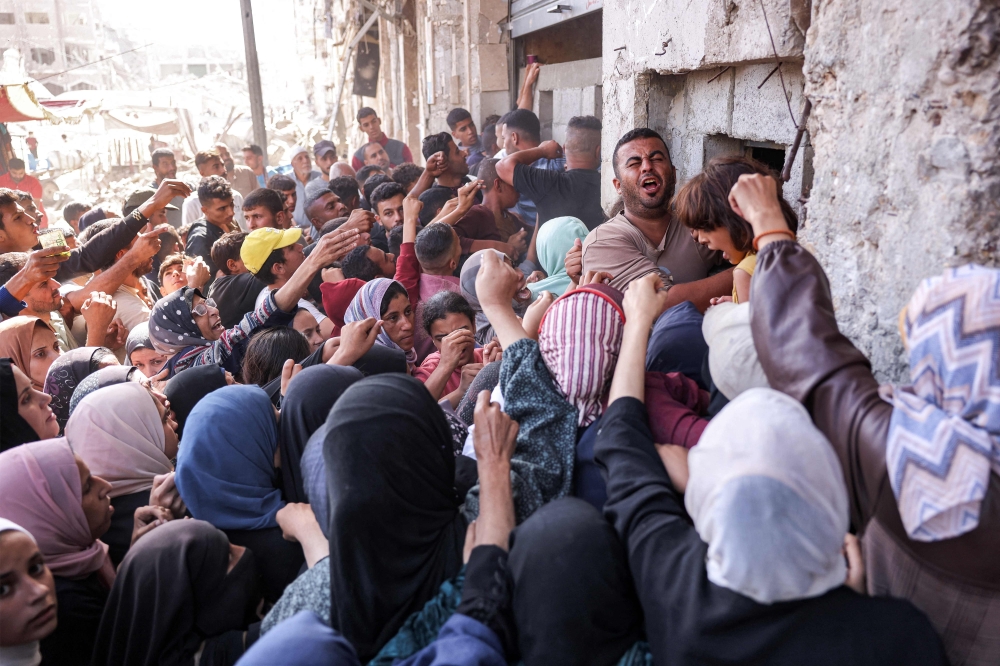 People crowd outside a bakery as they queue for bread in Khan Yunis in the southern Gaza Strip on October 23, 2024 amidst a flour shortage. — AFP pic 
