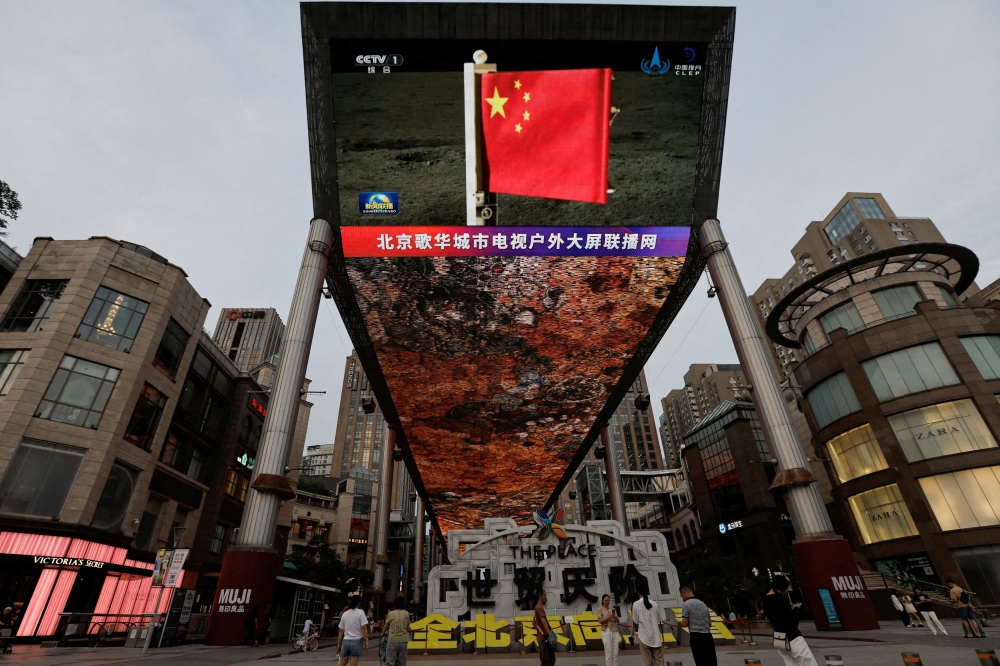 A large screen shows news footage of a Chinese national flag carried by Chang’e-6 probe’s lander on the far side of the moon, in Beijing, China June 4, 2024. China’s state security ministry said foreign spy intelligence agencies have been trying to steal secrets from the country’s space programme as the arms race in space intensifies. — Reuters pic 