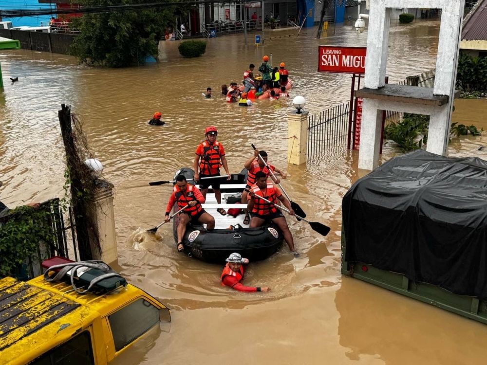 Philippine Coast Guard personnel evacuate residents after flood waters rose due to heavy rains brought by Tropical Storm Trami in Camarines Sur, Philippines October 24, 2024. — Reuters pic