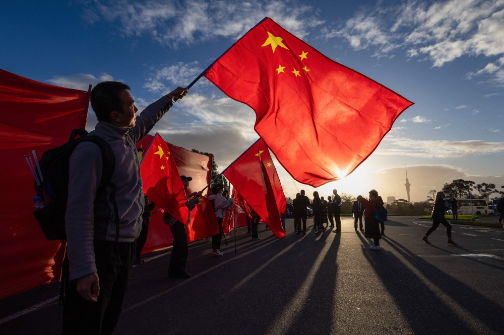 A file photo shows supporters of China's Premier Li Qiang waving Chinese national flags in Auckland, New Zealand, on June 14, 2024. — AFP pic