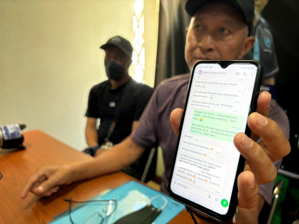 Abdul Rahman Hamid displays text messages purportedly from his son, Mohd Addie Azrinn Abdul Rahman, pleading for payments to a human trafficking syndicate.