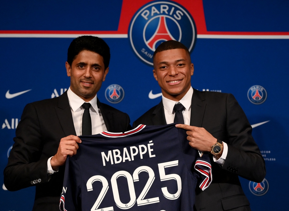 Paris Saint-Germain's CEO Nasser Al-Khelaifi (left) and French forward Kylian Mbappe (right) pose with a jersey at the end of a press conference at the Parc des Princes stadium in Paris on May 23, 2022. — AFP pic