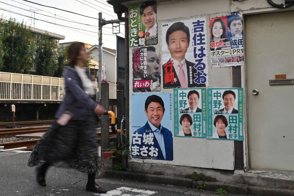 A woman walks past political posters early morning before the polls open for Japan’s general election in Tokyo on October 27, 2024. — AFP pic