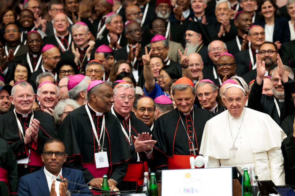 Pope Francis and clergy members pose for a photo at the Synod of Bishops at the Paul VI hall at the Vatican October 26, 2024. — Reuters pic