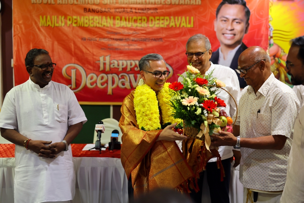  Lembah Pantai Member of Parliament Fahmi Fadzil, who is also the Communications Minister, receives a bouquet of flowers as a token of appreciation from the Arulmigu Temple Management Association chairman Valautham (right) at the Deepavali Voucher Giving Ceremony to 300 recipients in the Lembah Pantai Parliament area at the Arulmigu Sri Ramalingeswarar Kovil October 27, 2024. — Bernama pic