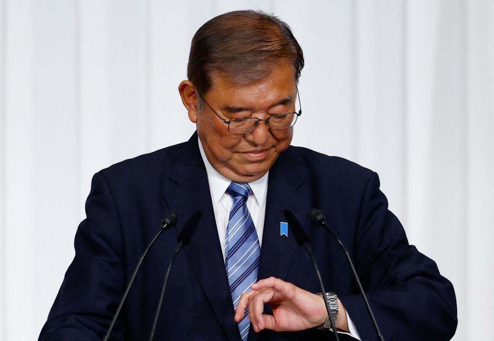 Shigeru Ishiba, Japan's Prime Minister and leader of the ruling Liberal Democratic Party (LDP), looks at his watch as he arrives for a press conference at the party's headquarters in Tokyo yesterday. — AFP pic