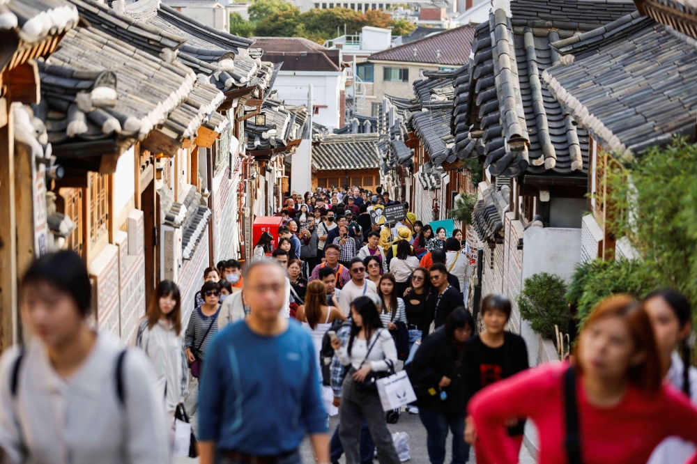 A large crowd of tourists walks through Bukchon Hanok Village in Seoul, South Korea, October 25, 2024. — Reuters pic