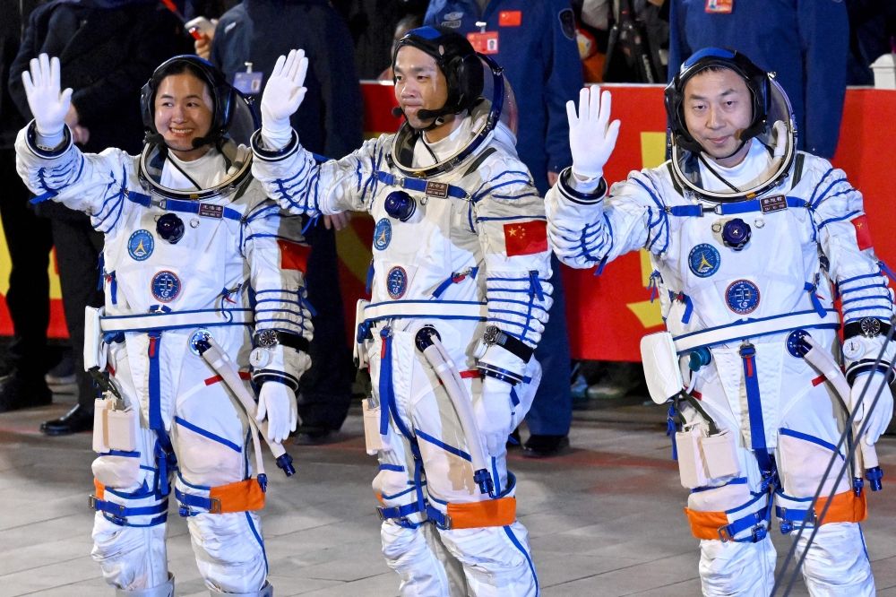 (R-L): Astronauts Cai Xuzhe, Song Lingdong and Wang Haoze wave to the crowd during a departure ceremony ahead of the launch of the Shenzhou-19 space mission at the Jiuquan Satellite Launch Centre in the Gobi desert earlier today. — AFP pic
