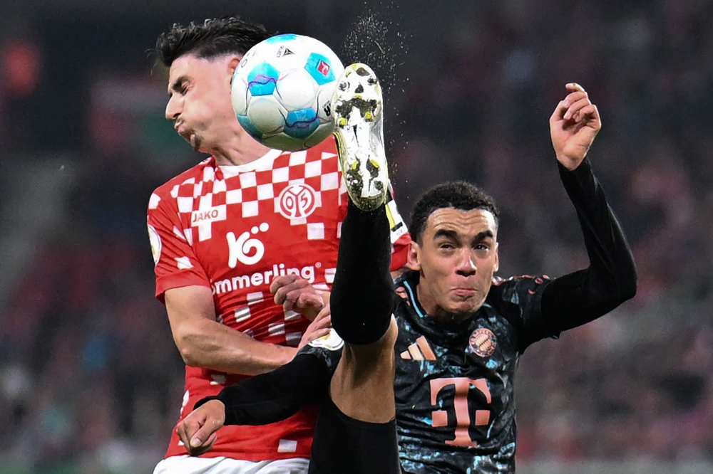 Bayern Munich’s German midfielder Jamal Musiala (right) vies vies for the ball with Mainz’ French defender Anthony Caci. — AFP pic