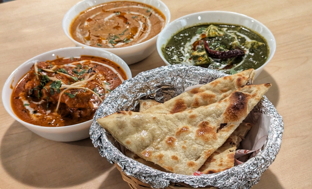 A basket of ‘naan’ with Chicken Changhezi, Daal Makhani and Palak Paneer. — Picture by Ethan Lau