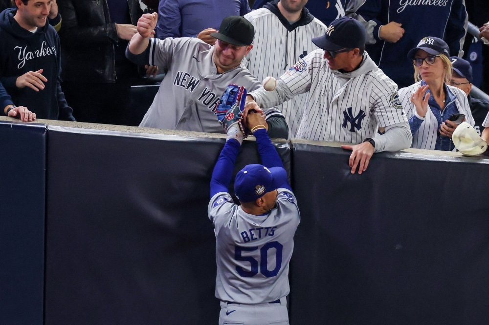 Two New York Yankees fans who interfered with Los Angeles Dodgers outfielder Mookie Betts as he tried to make a catch were barred from yesterday’s fifth game of the World Series. — AFP pic