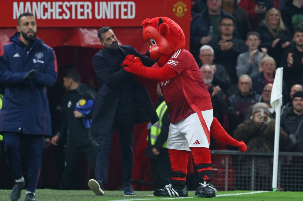 Manchester United's Dutch interim head coach Ruud van Nistelrooy is greeted by club mascot Fred The Red ahead of kick-off in the English League Cup round of 16 football match between Manchester United and Leicester City at Old Trafford in Manchester, north west England, on October 30, 2024. — AFP pic