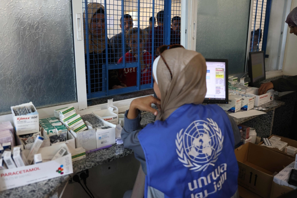 Palestinians queue to receive medicine at the UNRWA Japanese Health Center in Khan Yunis on the southern Gaza Strip on October 29, 2024, amid the ongoing war between Israel and the Palestinian group Hamas. Israel faced a mounting international backlash on October 29, after its parliament approved a bill banning the main UN aid agency for the devastated Gaza Strip. — AFP pic