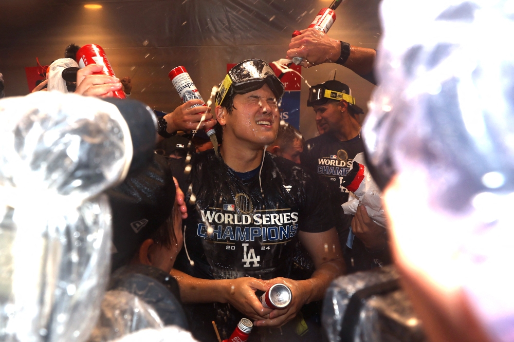 Shohei Ohtani of the Los Angeles Dodgers celebrates with teammates in the clubhouse after the Dodgers defeated the New York Yankees 7-6 in Game Five to win the 2024 World Series at Yankee Stadium in New York October 30, 2024. — AFP pic
