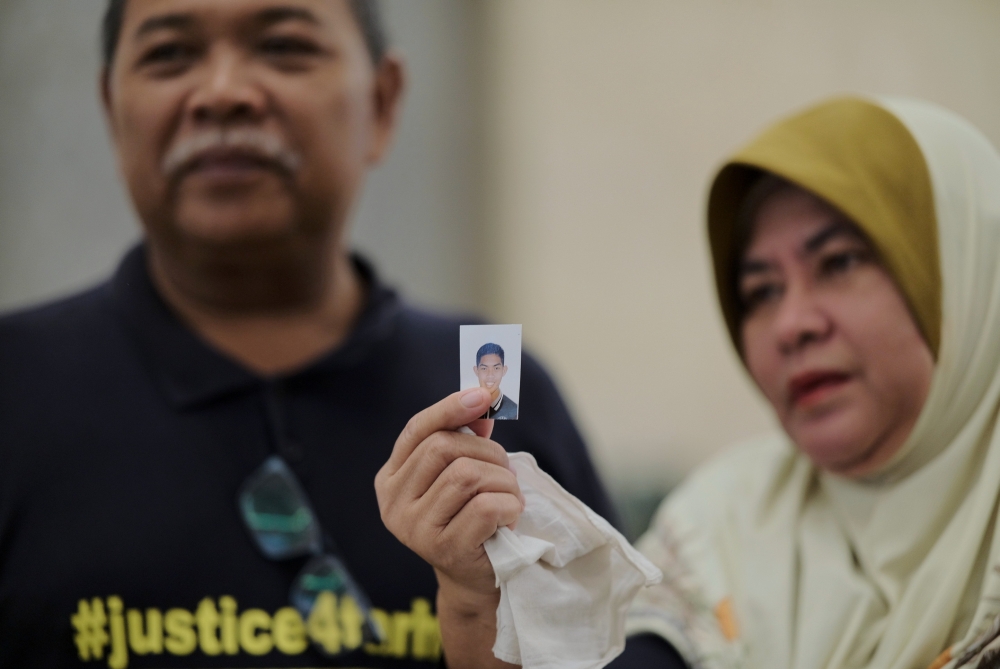 Zulkarnain Idros (left), father of murdered former Universiti Pertahanan Nasional Malaysia (UPNM) student Zulfarhan Osman Zulkarnain, and his wife Hawa Osman, hold a photo of their late son after the Court of Appeal sentenced six former UPNM students to death at the Palace of Justice in Putrajaya, July 23, 2024. — Bernama pic