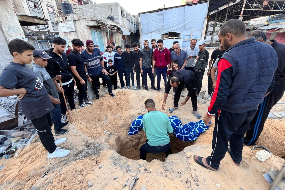 People bury a victim of Israeli bombing in the vicinity of the Kamal Adwan hospital in Beit Lahya in the northern Gaza Strip on October 31, 2024. — AFP pic 