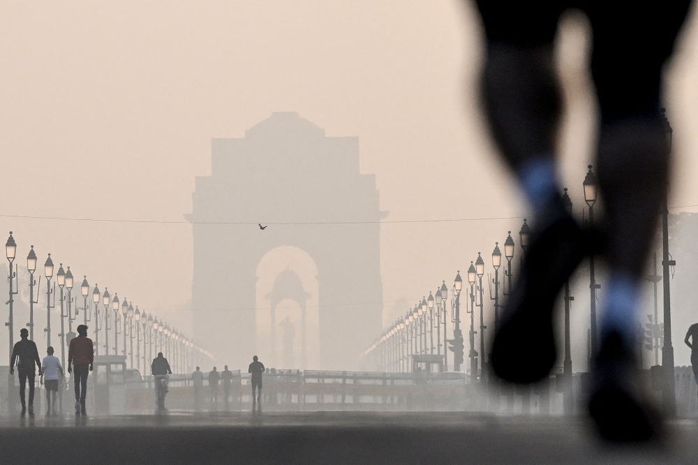 Pedestrians walk near the India gate amid smoggy conditions after Diwali, the Hindu festival of lights, in New Delhi on November 1, 2024. — AFP pic 
