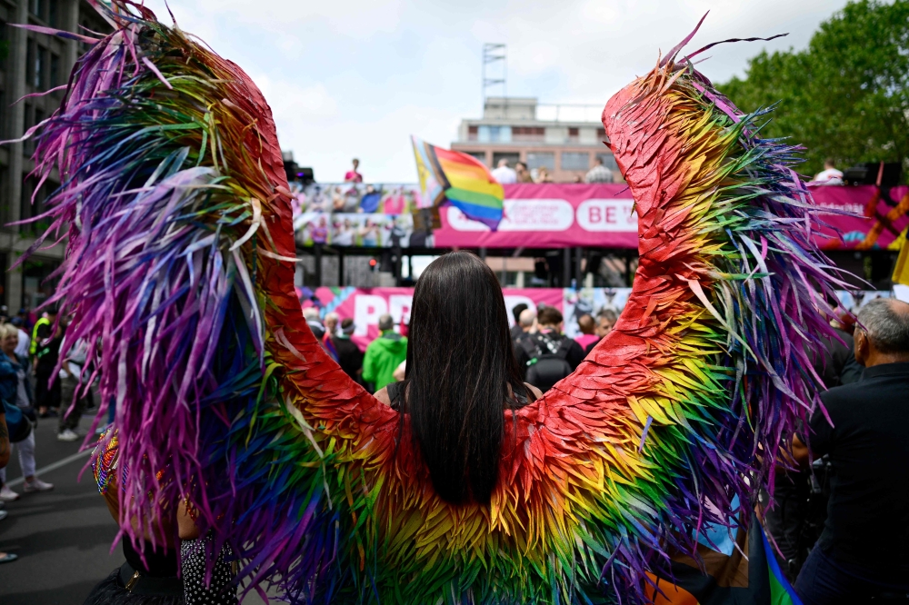 A participant wearing wings in the rainbow colours attends the yearly Christopher Street Day (CSD) parade in Berlin on July 22, 2023. Germans will be able to change their legal gender more easily from November 1, 2024  thanks to a new law hailed as a ‘historic’ step for the LGBTQ community. — AFP pic 
