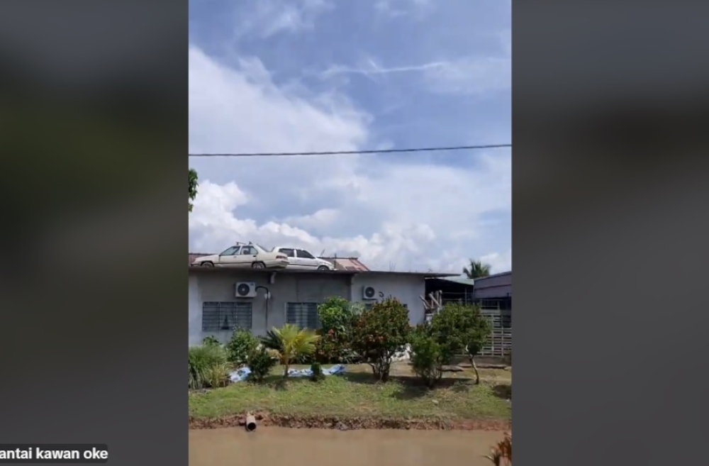 Due to the lack of parking, Awang Ali Abdullah decided to have a crane lift up the two cars so they would be out of the way and he said it took only 30 minutes. — Screengrab from TikTok