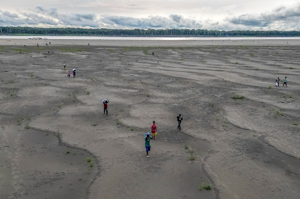  Aerial view of Yagua Indigenous people carrying water and other goods due to the low level of the Amazon river at Isla de los Micos, Amazonas department, Colombia, on October 4, 2024. — AFP pic