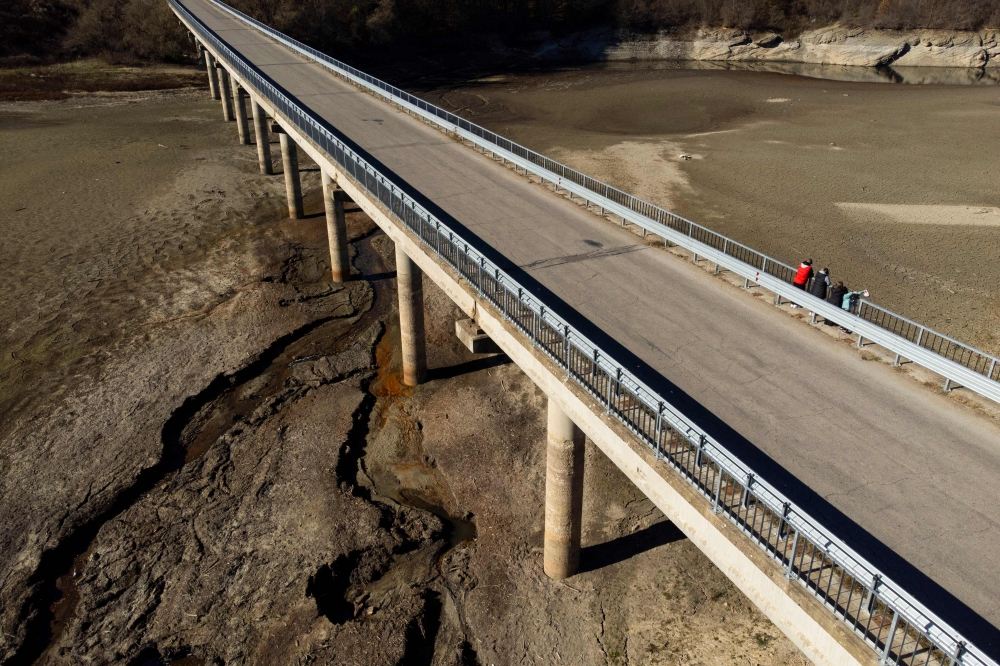 A car rides by the dried Yovkovtsi dam, near the town of Elena, Central Bulgaria on November 08, 2024. Nine of 12 dams supplying water to localities in Bulgaria are 65% full, and the drought in summer is perduring now in the autumn. More than 240.000 people in a country of 6,5 million are facing regular water shortages.— AFP pic