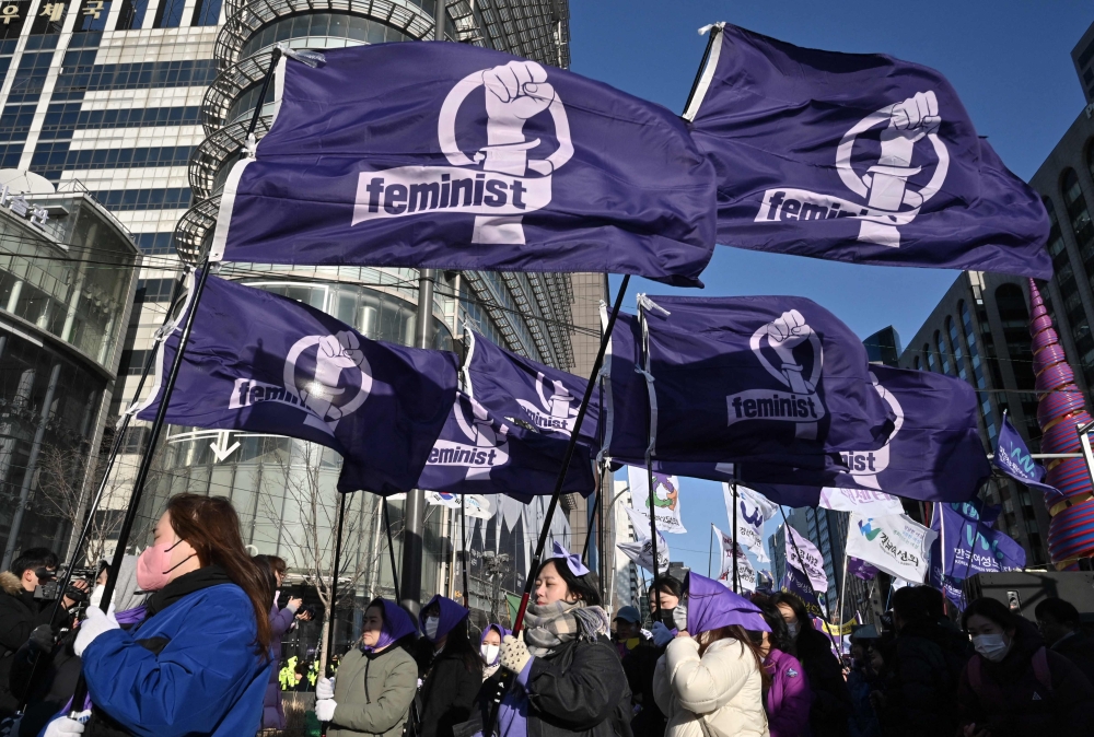 South Korean women carry flags reading ‘Feminist’ as they march during a rally to mark International Women’s Day in downtown Seoul on March 8, 2024. No dating, sex, marriage or having children with men: South Korea’s extreme feminist movement ‘4B’ has gone viral in America and beyond since Donald Trump won the US presidential election. — AFP pic 
