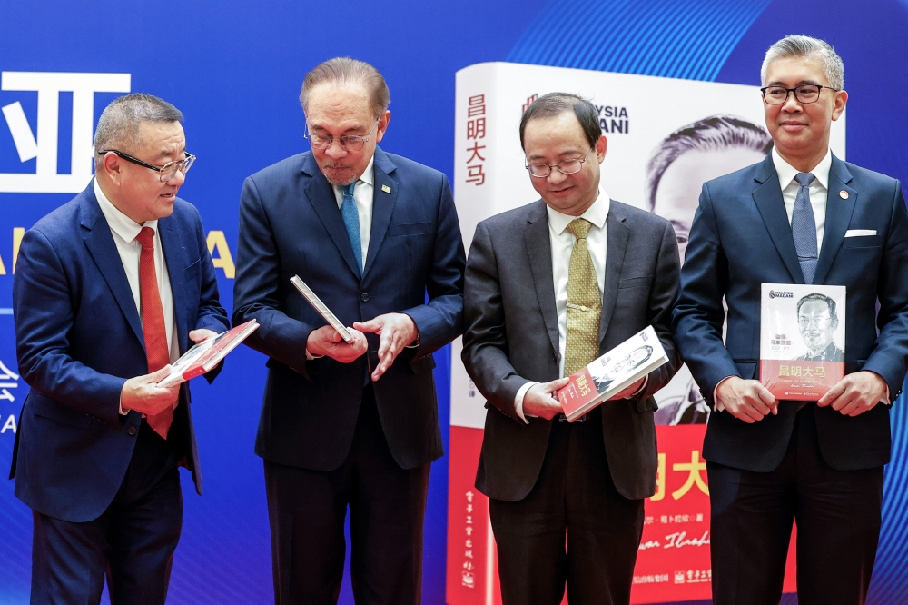 Prime Minister Datuk Seri Anwar Ibrahim (second left) and Investment, Trade and Industry Minister Tengku Datuk Seri Zafrul Aziz (right) introduce the book SCRIPT: For a Better Malaysia at the China World Hotel. — Bernama pic