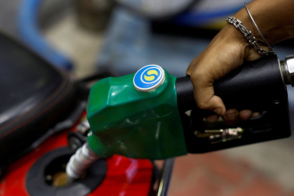 A worker holds a nozzle to pump fuel into a two-wheeler vehicle at a Bharat Petroleum oil and fuel station in Kolkata August 7, 2024. — Reuters pic  