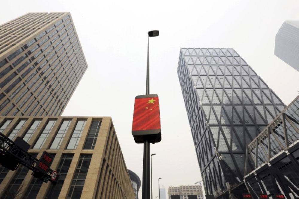 China’s national flag is seen among buildings at the Yujiapu financial centre in Tianjin. — Reuters file pic