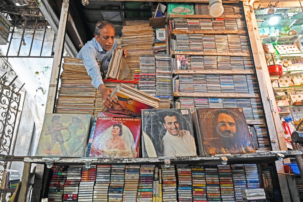 In this photograph taken on October 4, 2024, Royal Music Collection store owner Abdul Razzak, arranges vinyl records after opening his shop in Mumbai. — AFP pic