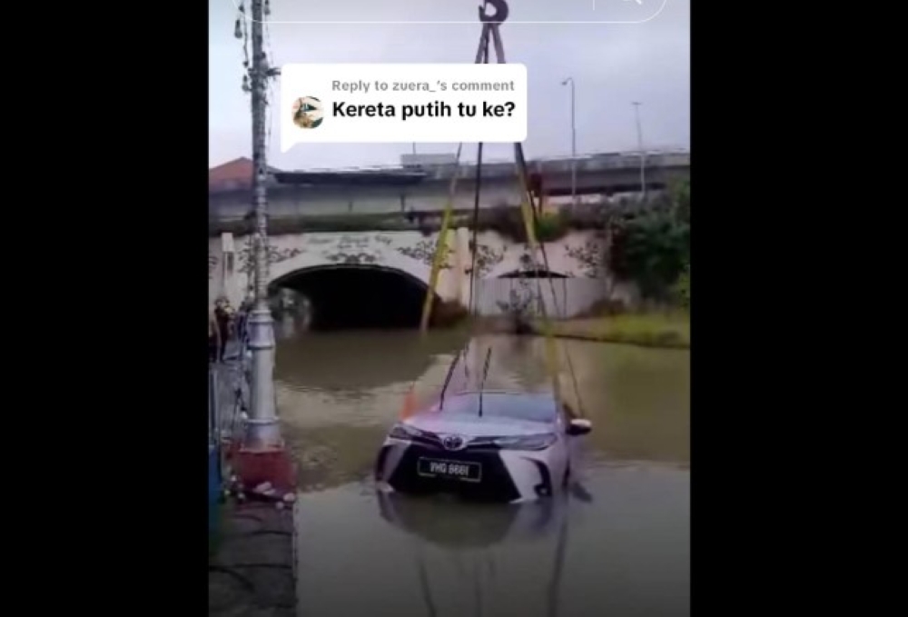 A e-hailing driver had a terrifying close call yesterday when her car skidded off the road and plunged into a lake near The Mines Shopping Mall in Seri Kembangan. — Picture via TikTok/@kakdiamond78