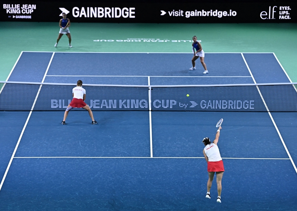 Poland's Iga Swiatek serves next to Poland's Katarzyna Kawa to Italy's Jasmine Paolini and Italy's Sara Errani during their semi-finals doubles tennis match between Poland and Italy at the Billie Jean King Cup Finals at the Palacio de Deportes Jose Maria Martin Carpena arena in Malaga, southern Spain November 18, 2024. — AFP pic